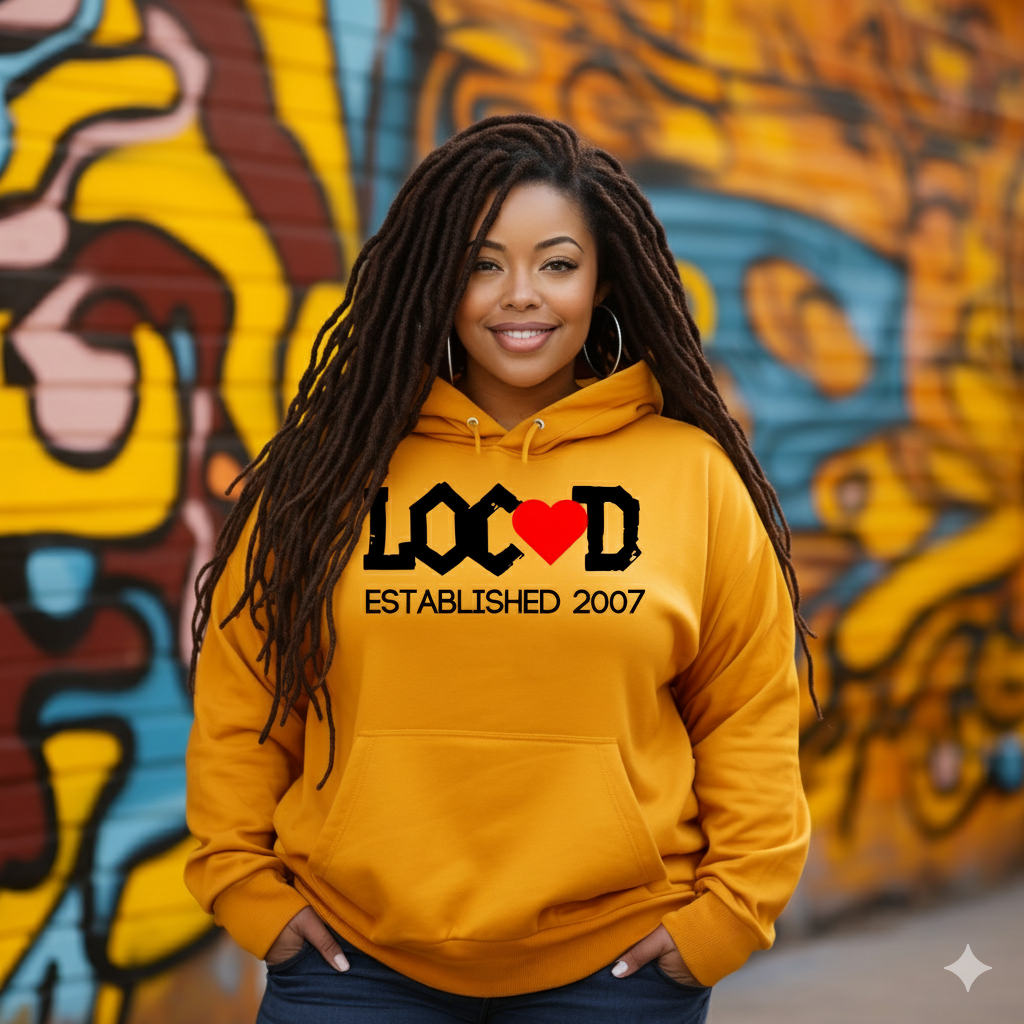 Woman wearing a yellow hoodie with 'LOCD' branding in front of a colorful mural.